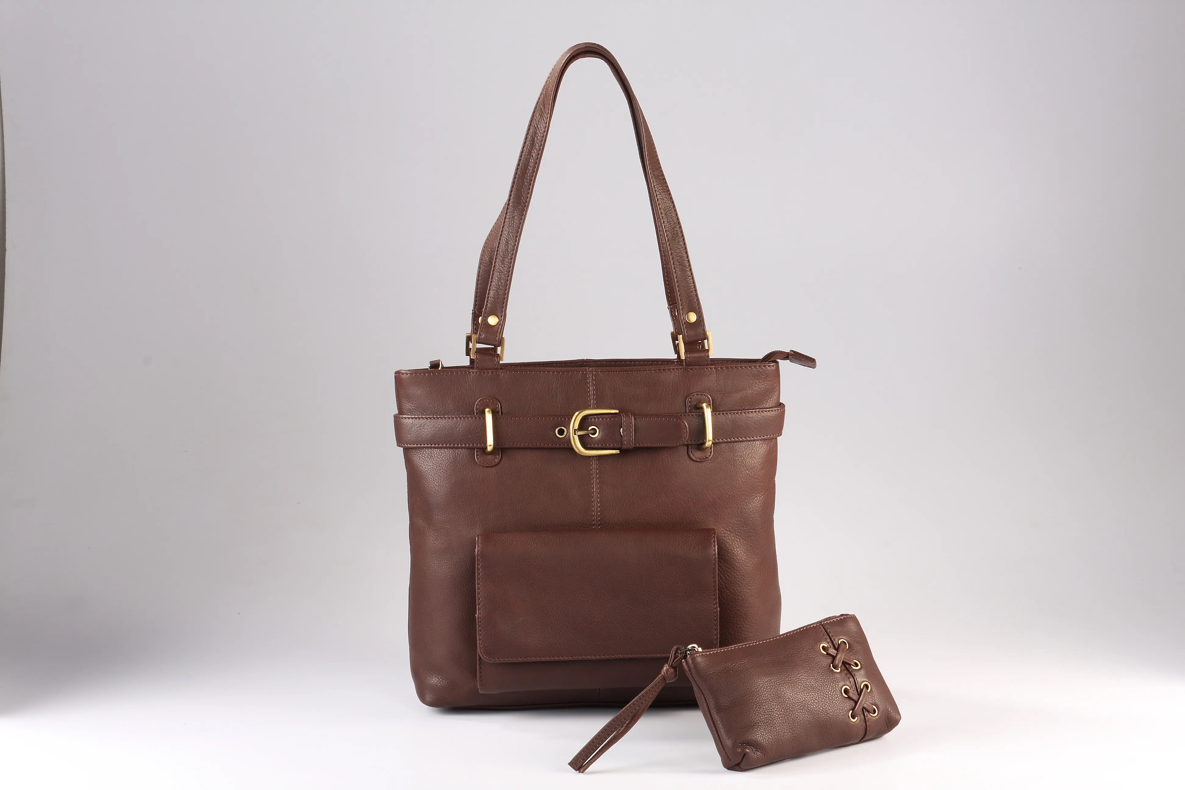 Brown NDM genuine leather tote bag with a front flap pocket, sturdy handles, and an additional small zippered pouch featuring lace detail, displayed on a neutral background.