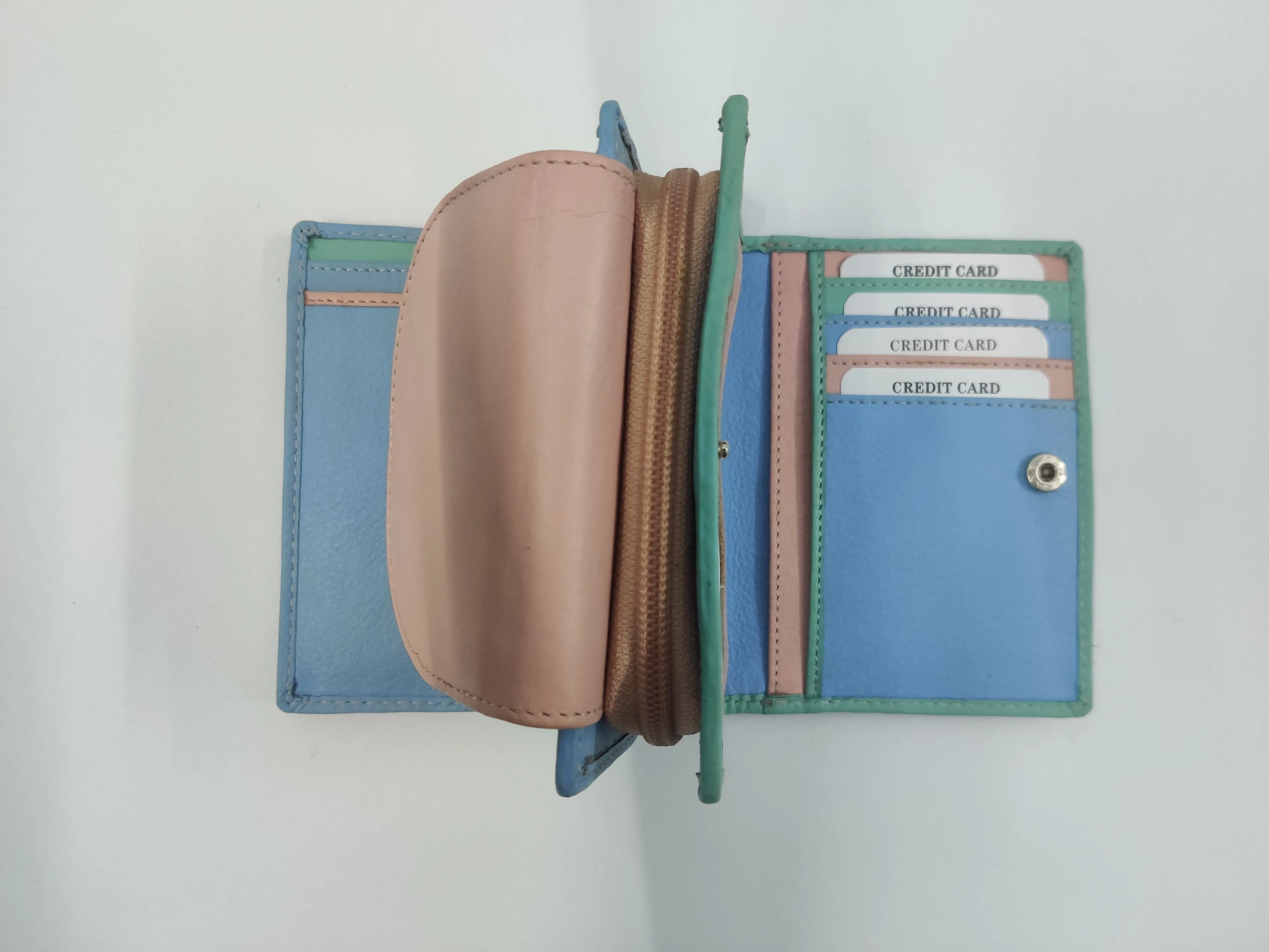Multi-coloured genuine leather purse with white thread detailing, multiple compartments, and a secure button and zipper closure.